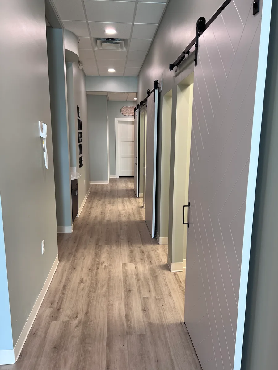 Hallway with barn doors leading to treatment rooms at Rabbit Creek Dental