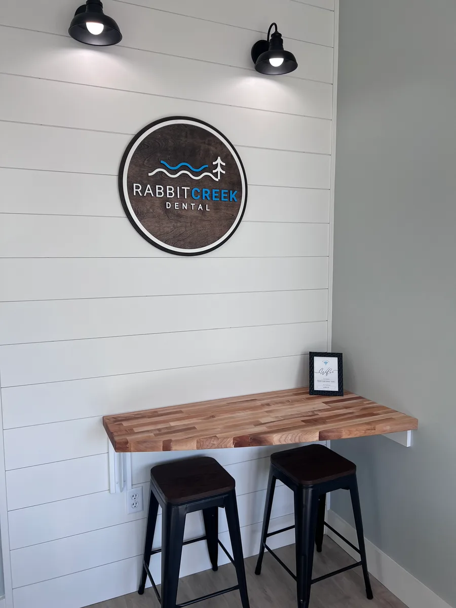 Rabbit Creek Dental logo on shiplap wall above butcher block bar